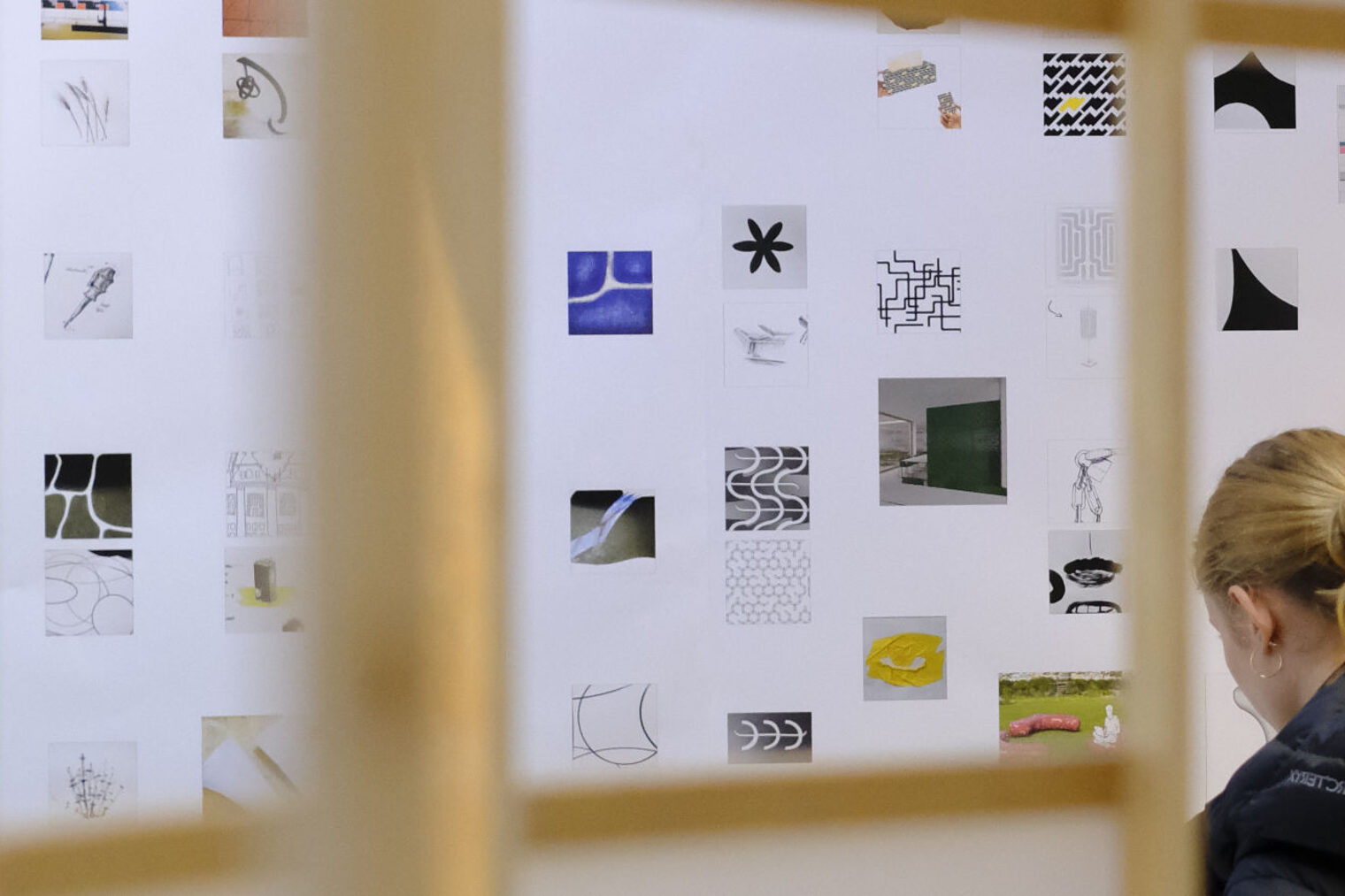 Junge Frau sitzt und arbeitet konzentriert an einem gestalterischem Konzept